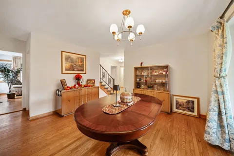 a view of a dining room with furniture a chandelier and wooden floor