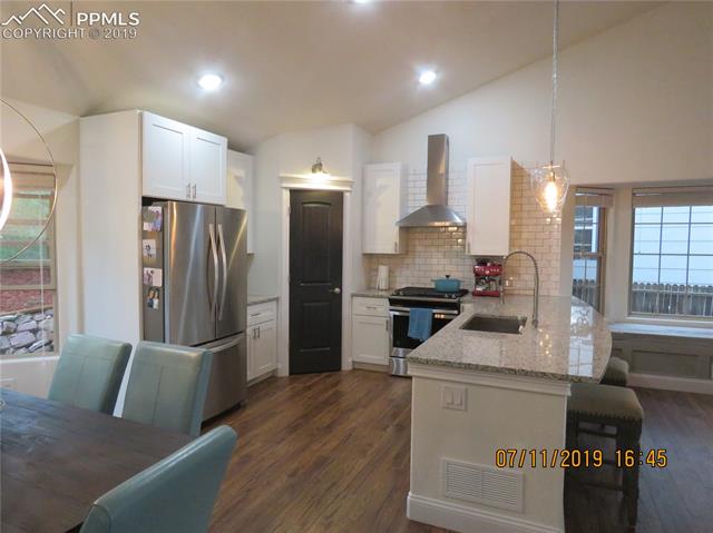 7799 Julynn Road Colorado Springs, CO 80919 - Photo 7 of 27 Granite counters and a stunning metal range hood make this the place to be.
