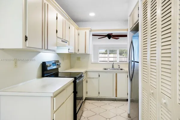 a kitchen with a stove a refrigerator and a sink