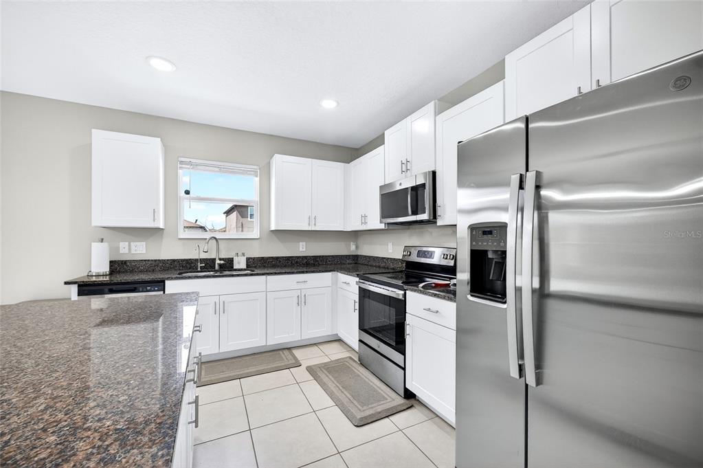 31724 Sun Kettle Loop Wesley Chapel, FL 33545 - Photo 2 of 49 a kitchen with stainless steel appliances granite countertop a stove a sink and a refrigerator