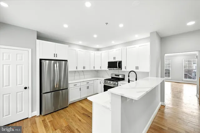 a kitchen with a refrigerator a sink and a stove top oven