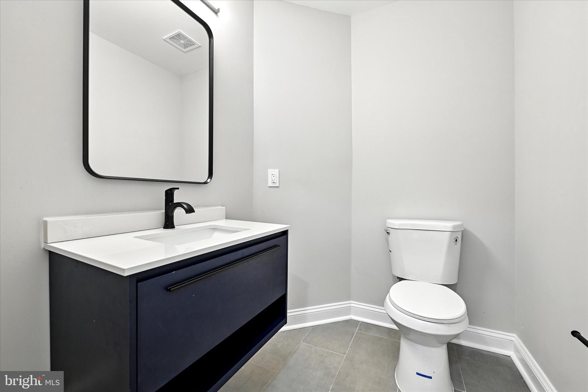 9828 Snow Bird Lane Laurel, MD 20723 - Photo 25 of 30 a bathroom with a toilet sink and mirror