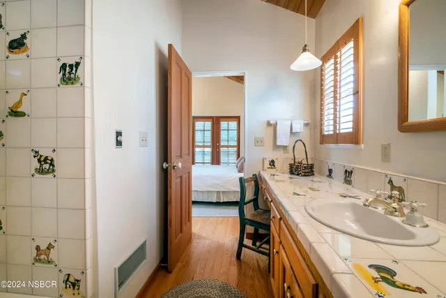 a en suite bathroom with a double vanity sink a mirror and a bathtub