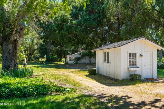 a view of a house with backyard and sitting area