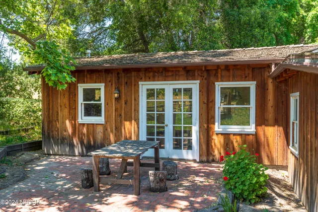 a view of a house with backyard sitting area and garden