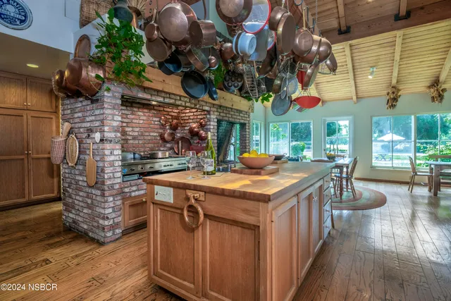 a kitchen with stainless steel appliances granite countertop a stove a sink and a wooden floors