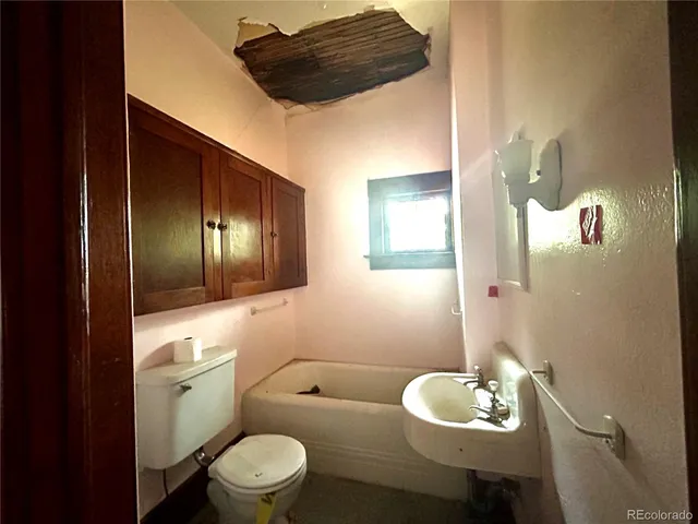 a bathroom with a toilet sink and mirror