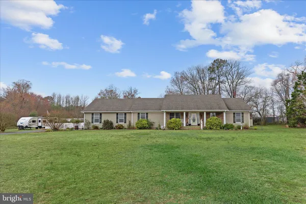 a view of a house with a big yard and large trees
