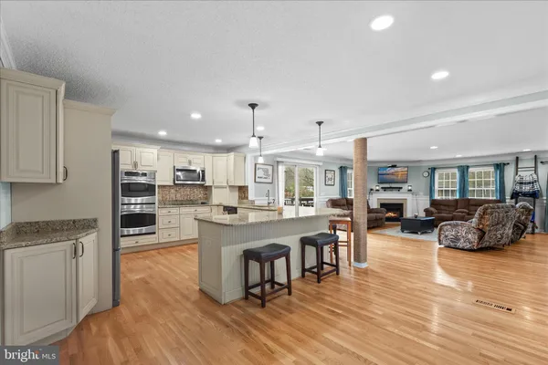 a kitchen with granite countertop white cabinets white stainless steel appliances and a sink