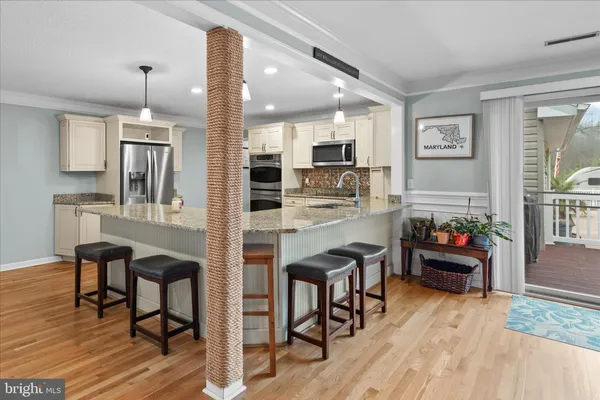 a kitchen with kitchen island a sink stainless steel appliances and cabinets