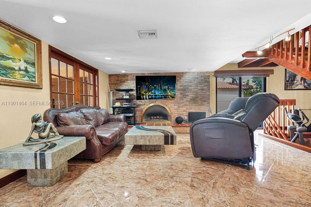 9291 Southwest 36th Street Miami, FL 33165 - Photo 5 of 15 a living room with furniture a fireplace and a flat screen tv