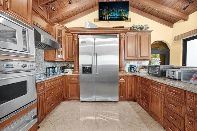 a large kitchen with stainless steel appliances granite countertop a stove a sink and a refrigerator