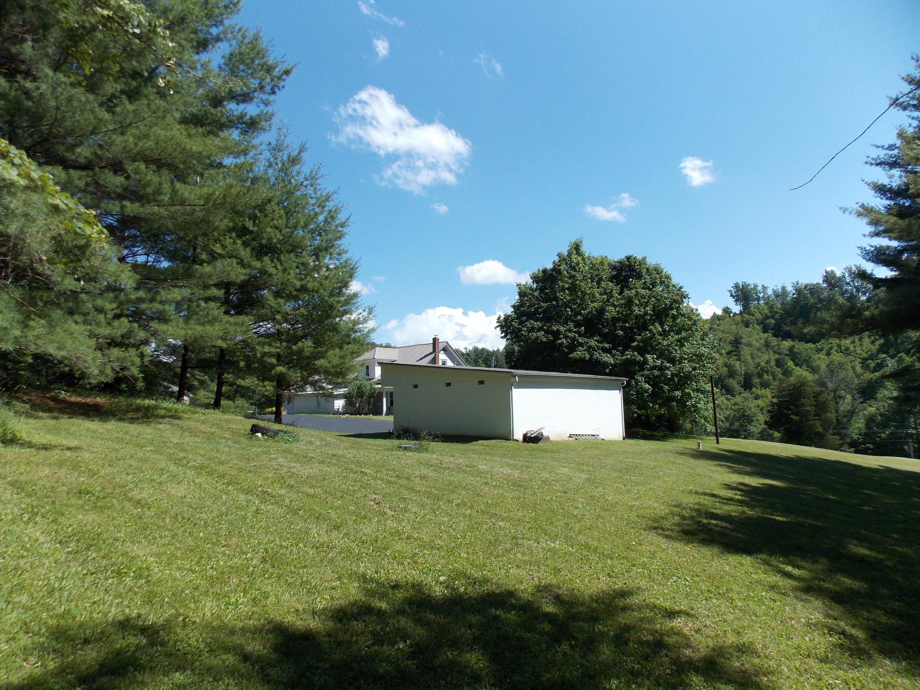 4147 Webbs Mill Road North Riner, VA 24149 - Photo 26 of 53 a view of a white house with a big yard and large trees