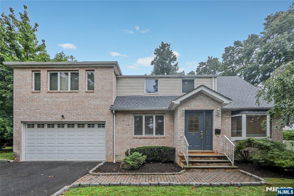 99 Park Avenue Cresskill, NJ 07626 - Photo 2 of 46 a front view of a house with a yard and potted plants