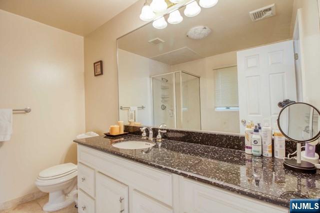 99 Park Avenue Cresskill, NJ 07626 - Photo 32 of 46 a bathroom with a granite countertop sink a toilet and a mirror