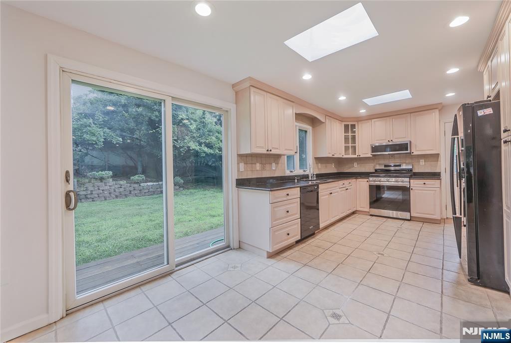 99 Park Avenue Cresskill, NJ 07626 - Photo 5 of 46 a kitchen with stainless steel appliances granite countertop a stove a sink a microwave and a refrigerator