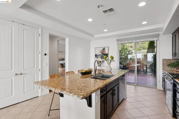 a kitchen with granite countertop kitchen island stainless steel appliances a table and chairs