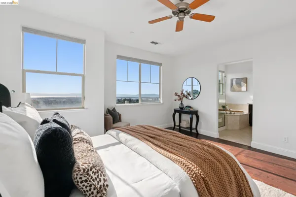 a bedroom with a bed a dresser and windows