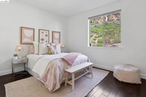 a bedroom with a bed a table and painting on the wall