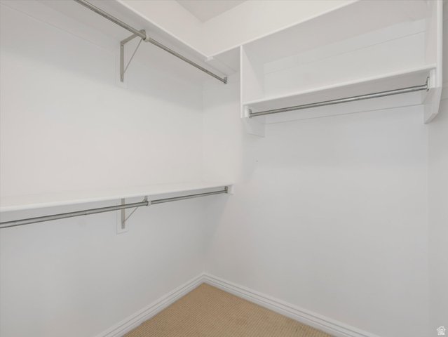 352 Haven Crest Road Draper, UT 84020 - Photo 33 of 44 Walk-in closet featuring white walls, white shelving, metal hanging rods, and light brown carpet