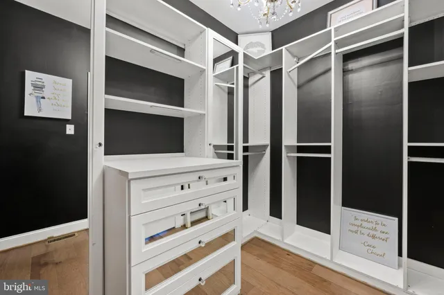 a view of walk in closet with clothes and shoes