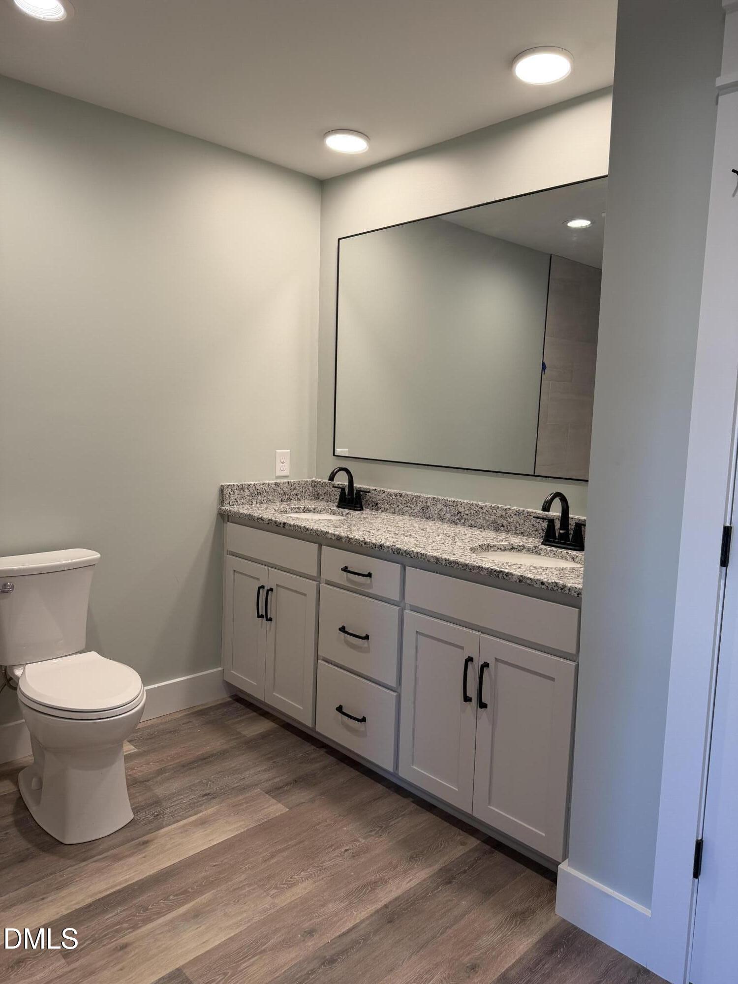 3055 Autry Mill Road Godwin, NC 28344 - Photo 11 of 21 a bathroom with a granite countertop sink a toilet and a mirror