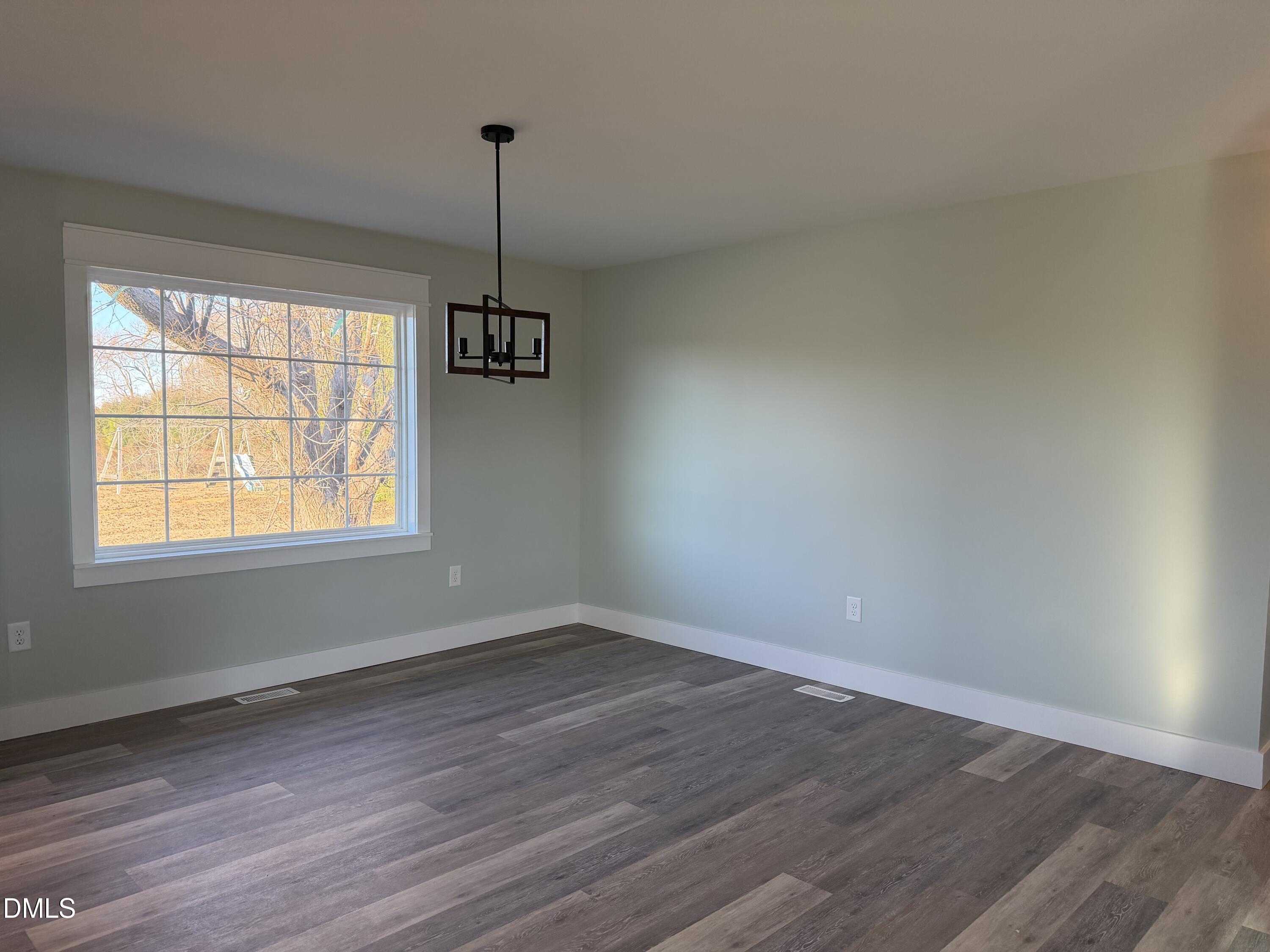 3055 Autry Mill Road Godwin, NC 28344 - Photo 8 of 21 a view of an empty room with wooden floor and a window