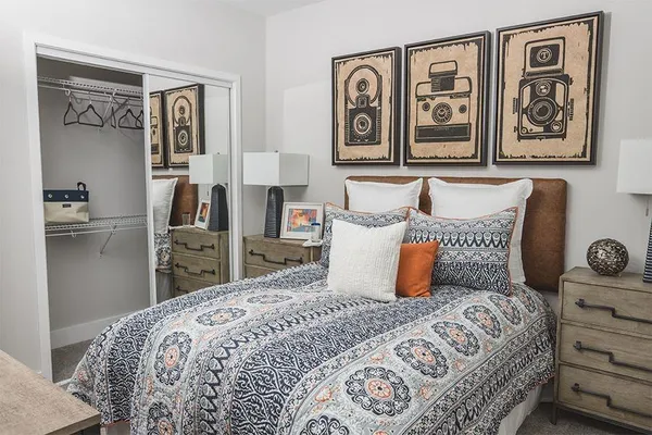 a bedroom with a large bed and paintings on the wall