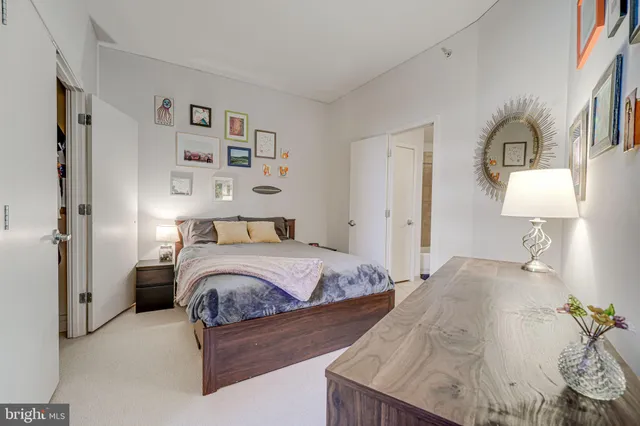 a bedroom with a bed a mirror and lamp