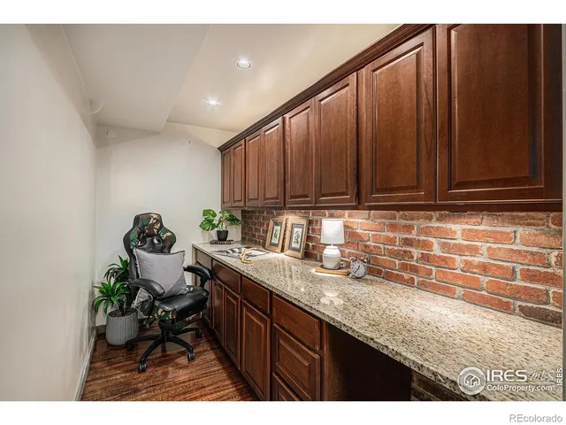 a kitchen with granite countertop a sink cabinets and wooden floor