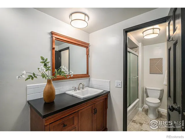 a bathroom with a sink vanity granite and a toilet