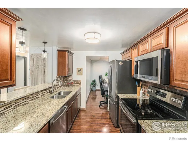 a kitchen with stainless steel appliances kitchen island granite countertop a stove and a sink