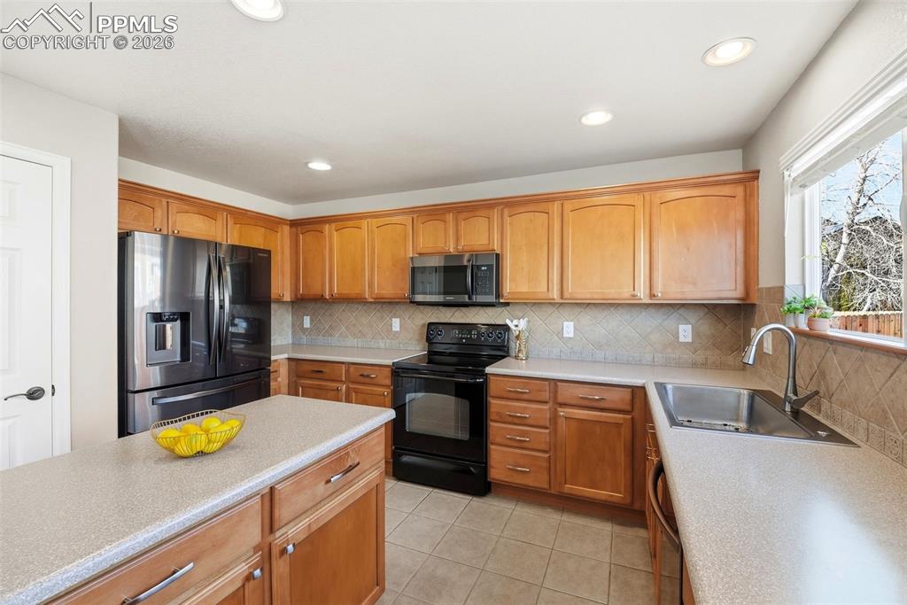 8318 Shadow Run Lane Fountain, CO 80817 - Photo 17 of 50 a kitchen with a sink a stove and cabinets