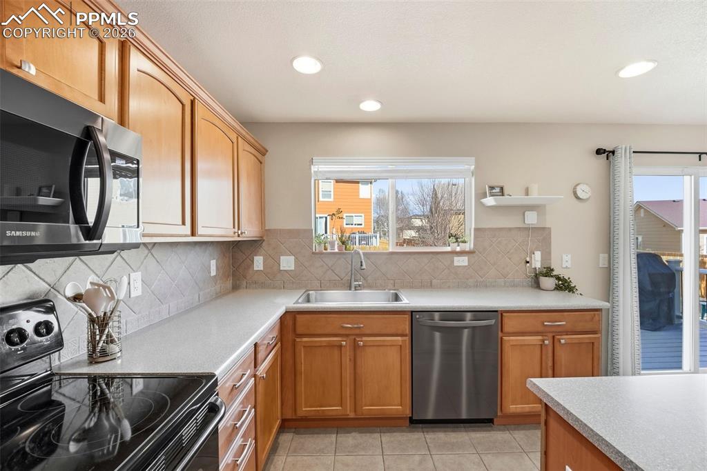 8318 Shadow Run Lane Fountain, CO 80817 - Photo 18 of 50 a kitchen with stainless steel appliances granite countertop a sink stove and cabinets