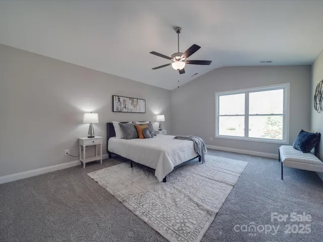 a bedroom with a large bed and a chandelier