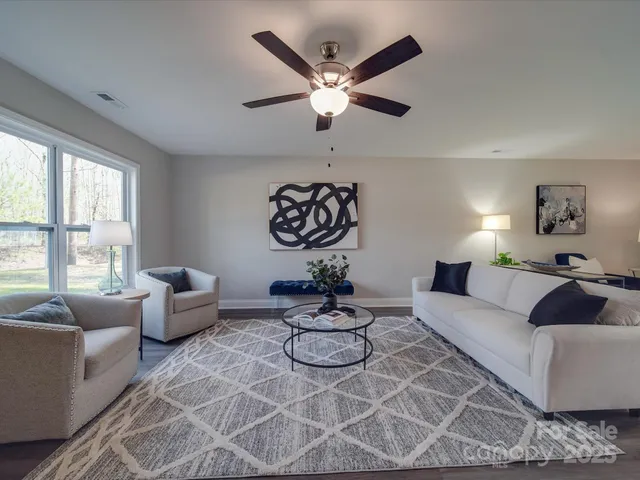 a living room with furniture a large window and a chandelier