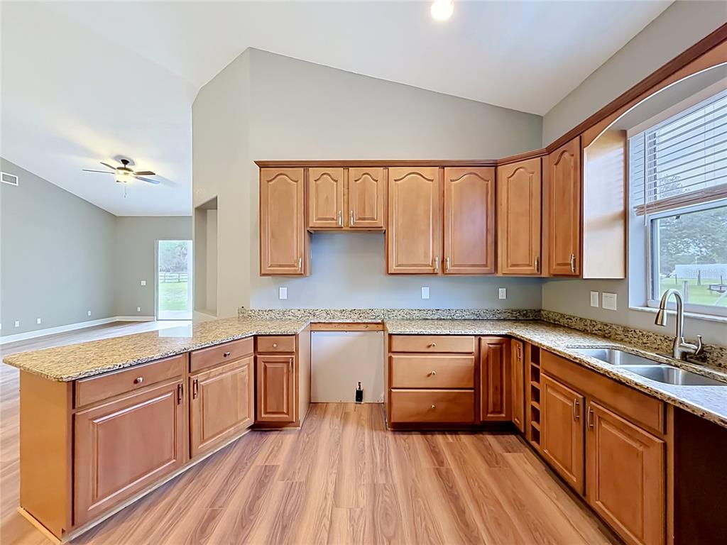 28549 Shirley Shores Road Tavares, FL 32778 - Photo 24 of 65 a kitchen with granite countertop sink stove and cabinets