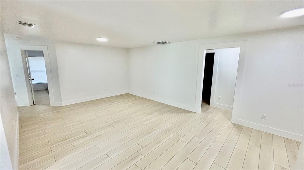 712 19th Street Orlando, FL 32805 - Photo 18 of 28 a view of an empty room with wooden floor and a window
