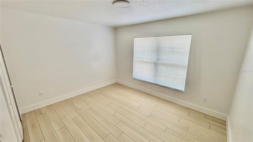 712 19th Street Orlando, FL 32805 - Photo 22 of 28 an empty room with wooden floor and windows