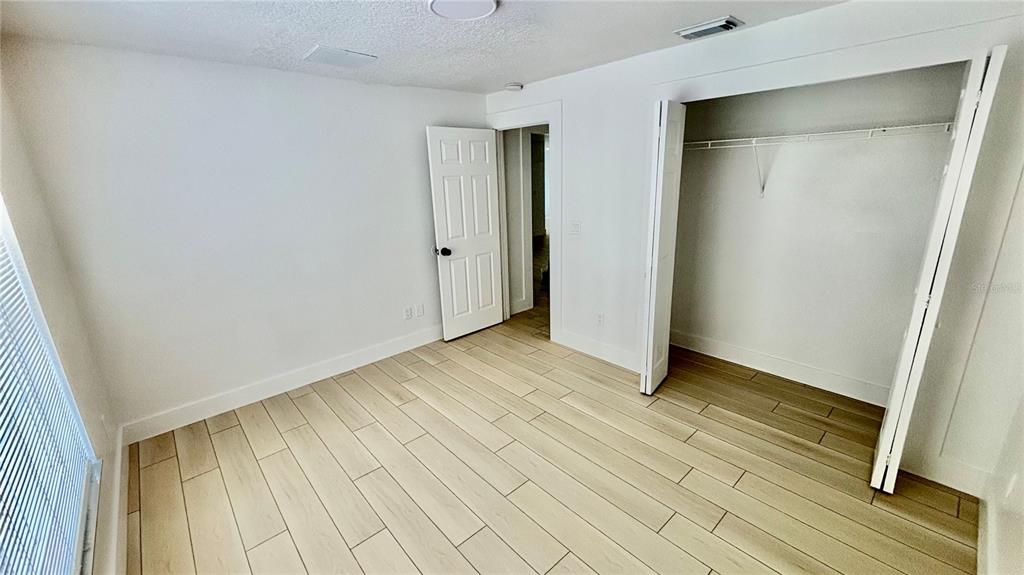 712 19th Street Orlando, FL 32805 - Photo 23 of 28 a view of an empty room with wooden floor and a window