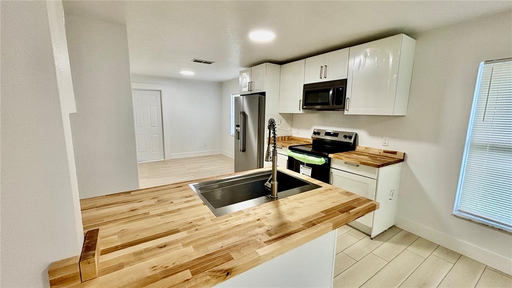 712 19th Street Orlando, FL 32805 - Photo 6 of 28 a kitchen with granite countertop cabinets stainless steel appliances and a window