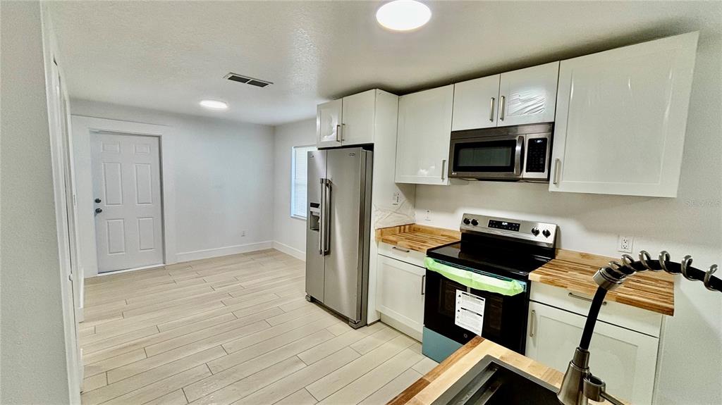 712 19th Street Orlando, FL 32805 - Photo 7 of 28 a kitchen with wooden cabinets and stainless steel appliances