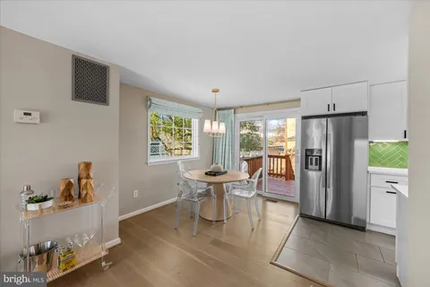 a kitchen with a refrigerator and wooden floor