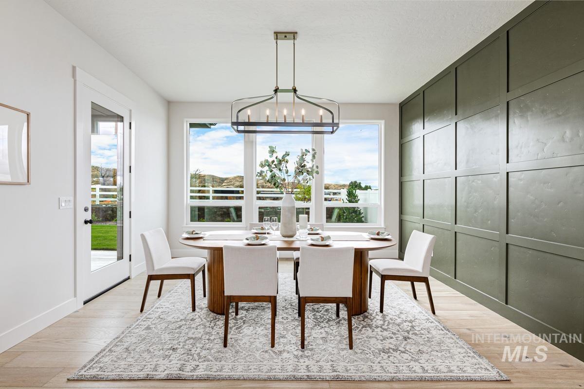6774 Saddle Bred Way Star, ID 83669 - Photo 11 of 41 Dining room with a decorative wall, light wood-style flooring, and a chandelier