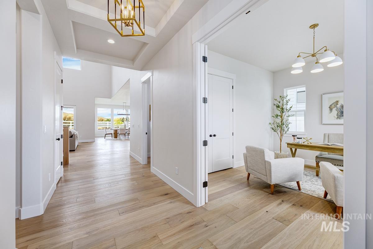 6774 Saddle Bred Way Star, ID 83669 - Photo 17 of 41 Hall with a chandelier, light wood-style flooring, an office area, and a towering ceiling