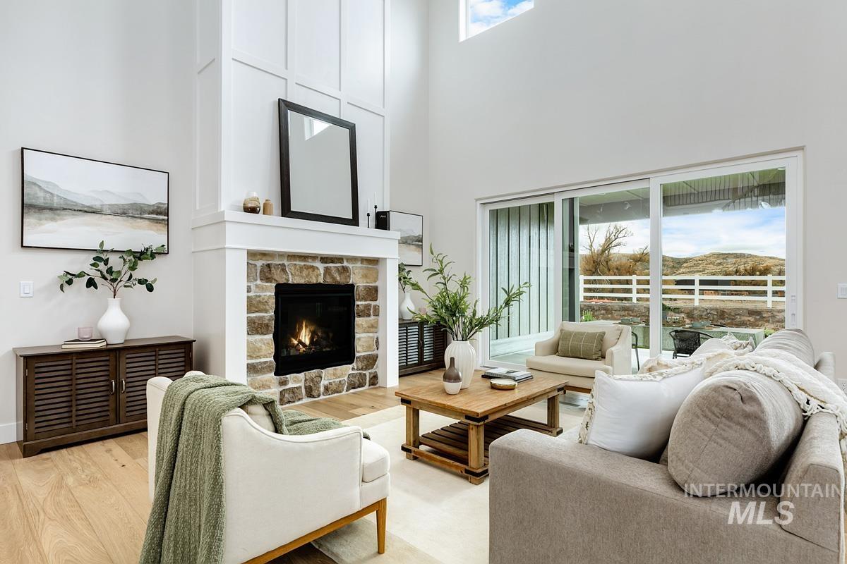 6774 Saddle Bred Way Star, ID 83669 - Photo 2 of 41 Living area featuring a high ceiling, a fireplace, and light wood-style flooring