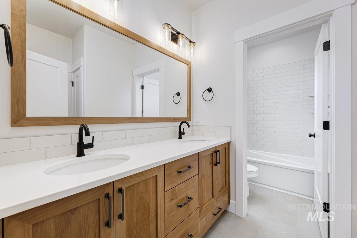 6774 Saddle Bred Way Star, ID 83669 - Photo 26 of 41 Full bathroom with double vanity, light tile patterned flooring, tub / shower combination, and tasteful backsplash