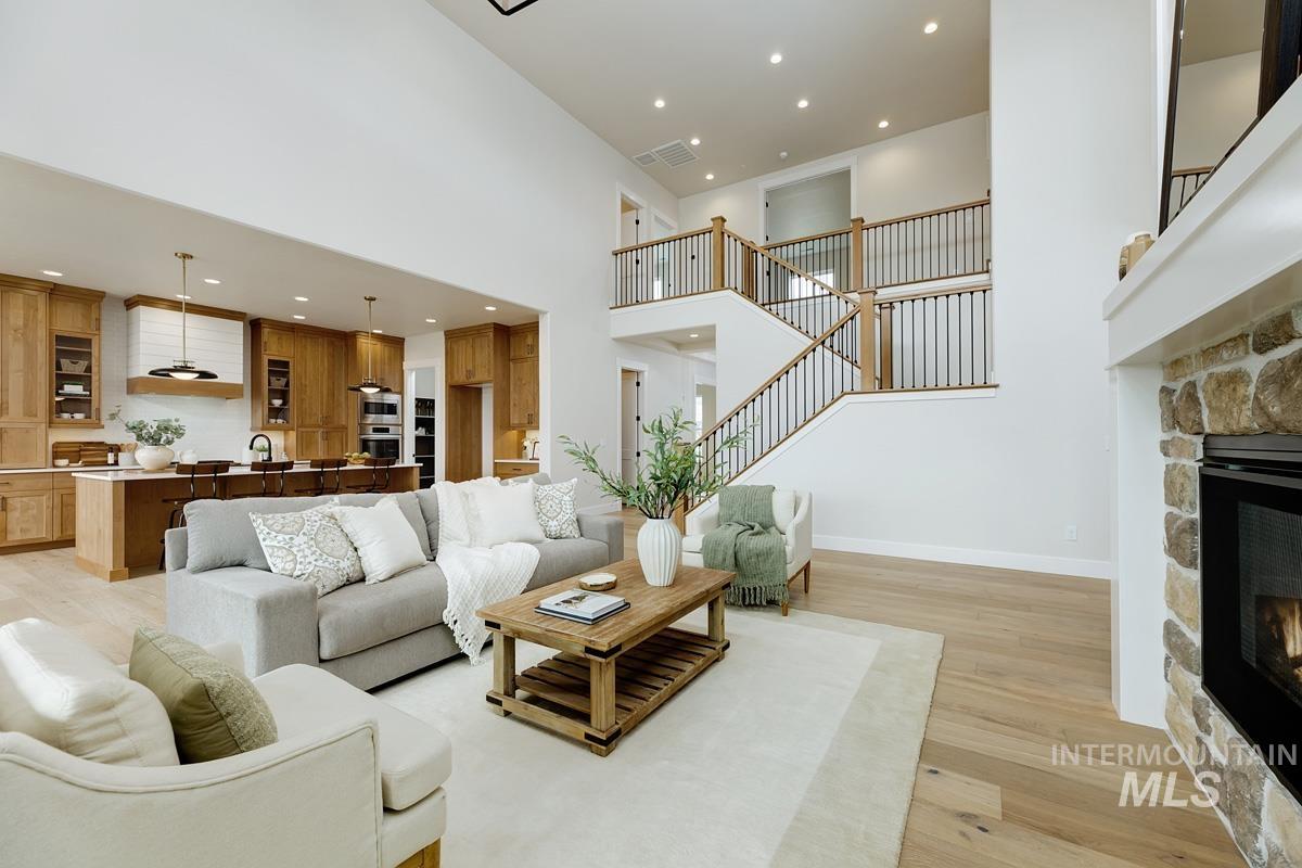 6774 Saddle Bred Way Star, ID 83669 - Photo 6 of 41 Living area with light wood-type flooring, a fireplace, a high ceiling, recessed lighting, and stairs