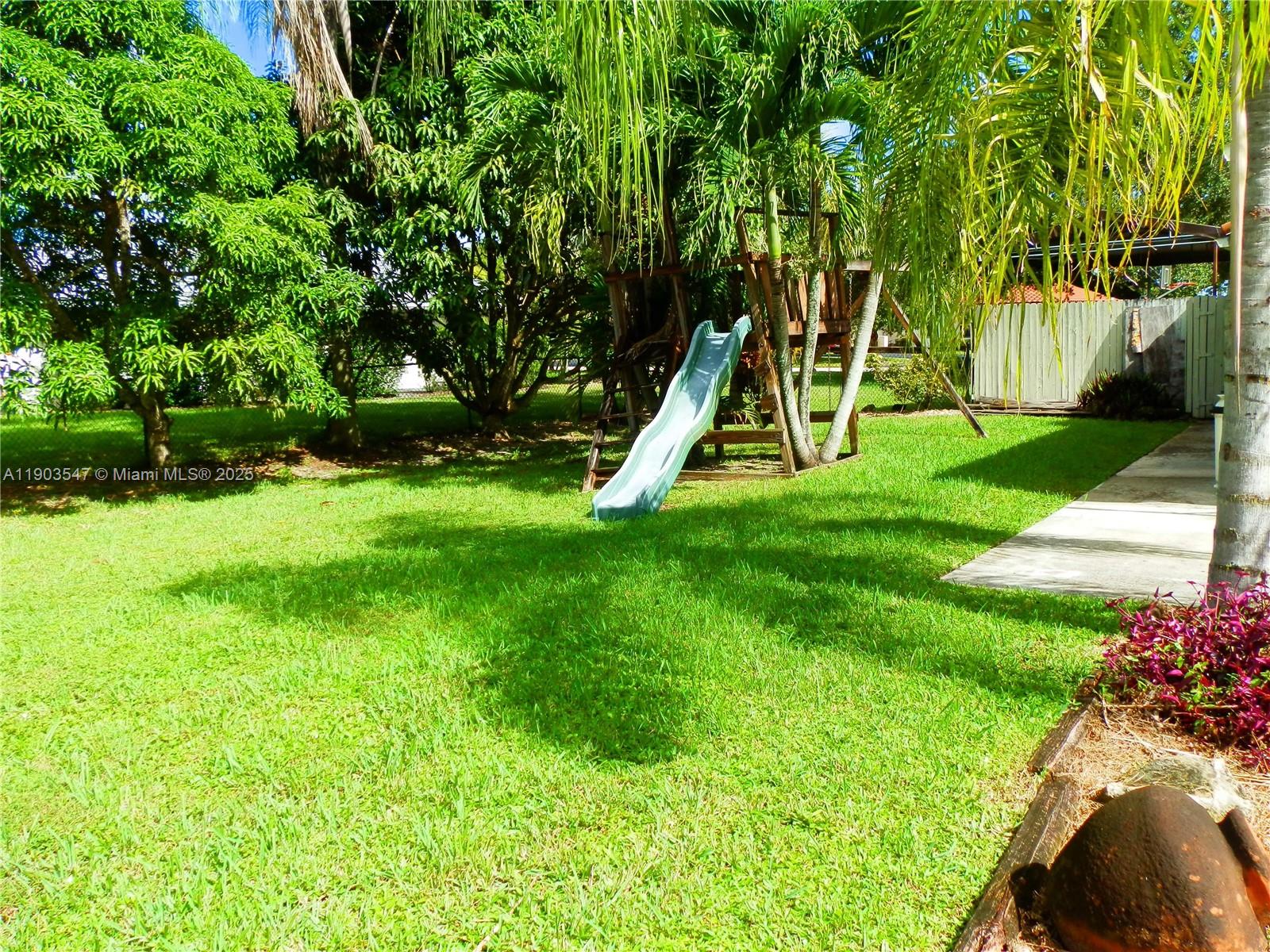 2700 Northwest 112th Avenue, Unit 2700 Coral Springs, FL 33065 - Photo 14 of 18 a view of a garden with a slide