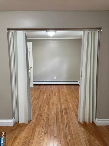 a view of empty room with wooden floor